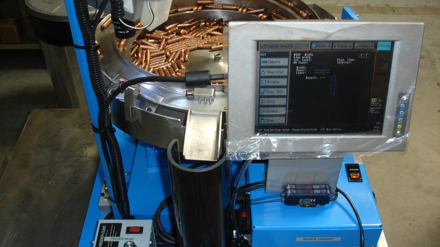 Feeder bowl presenting copper projectiles to a camera inspection station